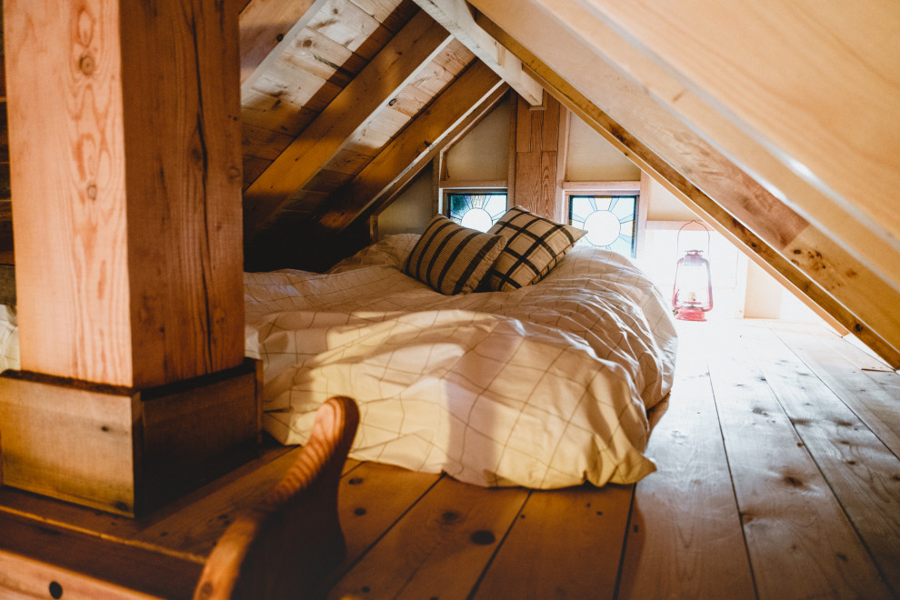 Imagen de dormitorio tipo loft rústico pequeño con paredes multicolor, suelo de madera clara, suelo multicolor, vigas vistas y panelado
