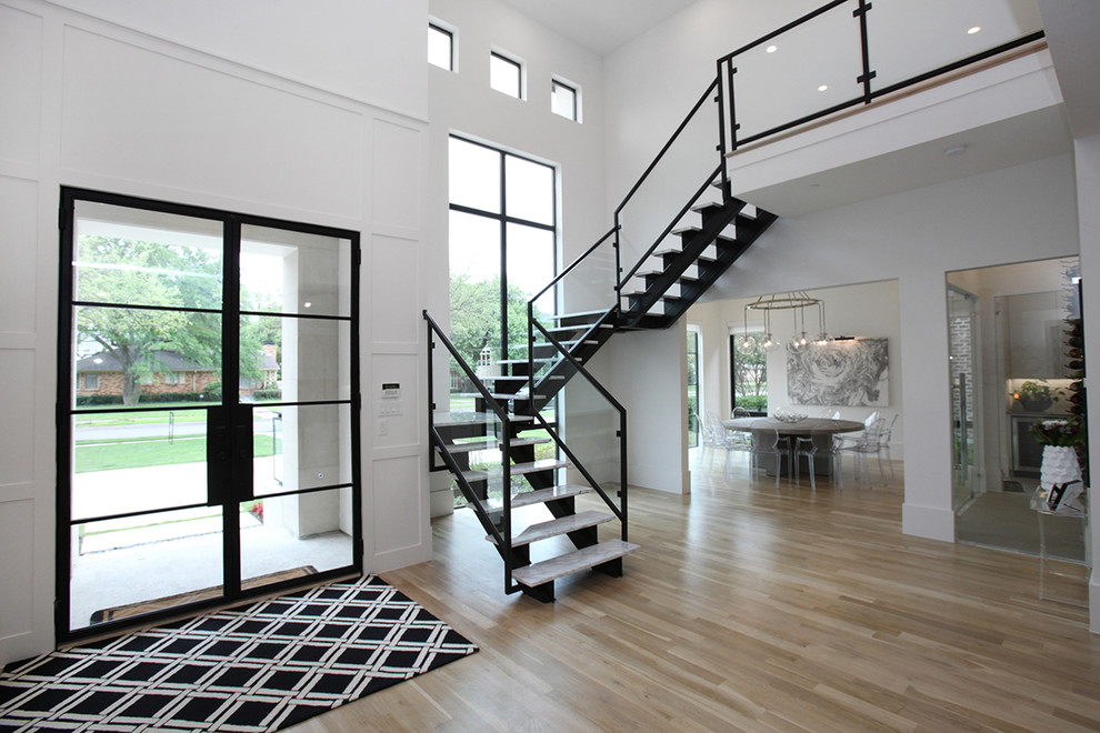 Photo of a large modern foyer in Dallas with white walls, light hardwood floors, a double front door, a black front door and beige floor.