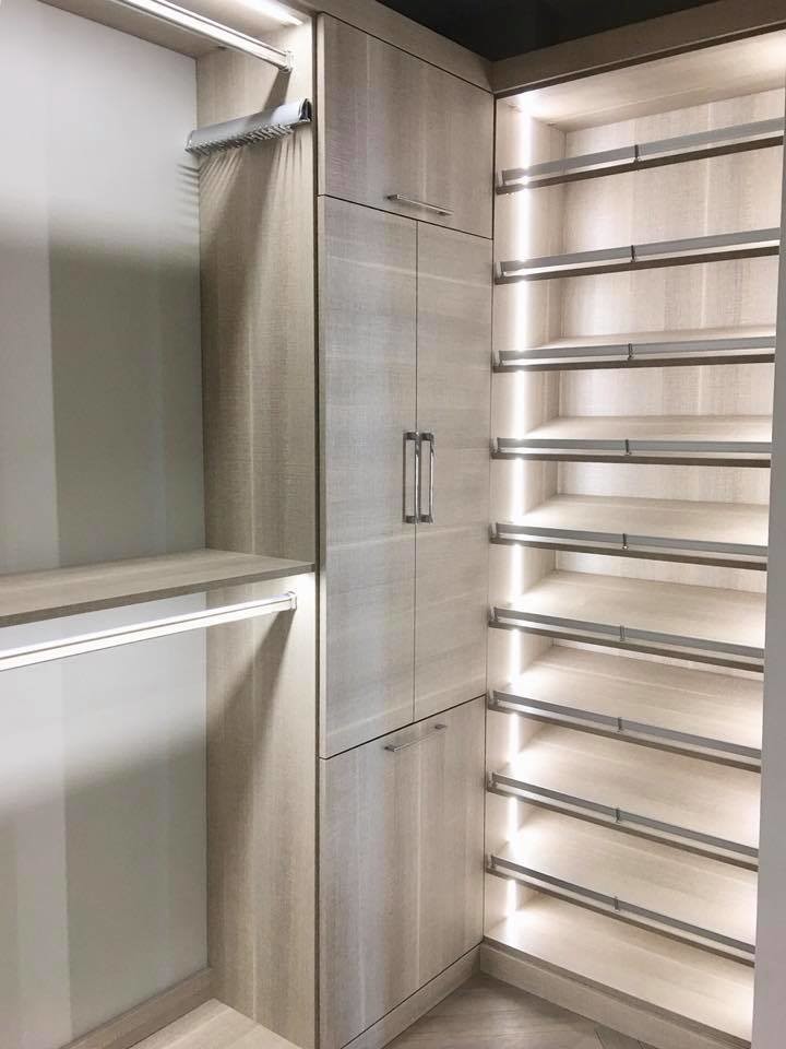 Photo of a mid-sized contemporary gender-neutral walk-in wardrobe in Tampa with flat-panel cabinets, medium wood cabinets, medium hardwood floors and multi-coloured floor.
