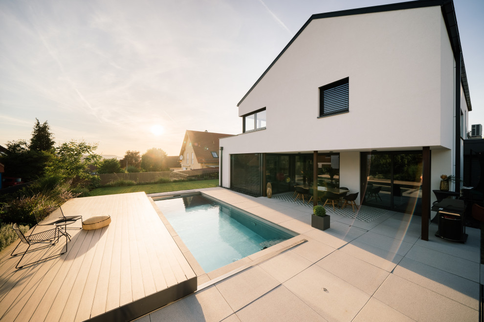 Imagen de piscina alargada actual rectangular en patio con paisajismo de piscina