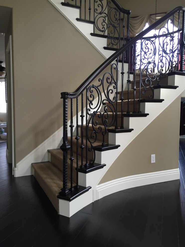 Large mediterranean carpeted curved staircase in Orange County with carpet risers and mixed railing.