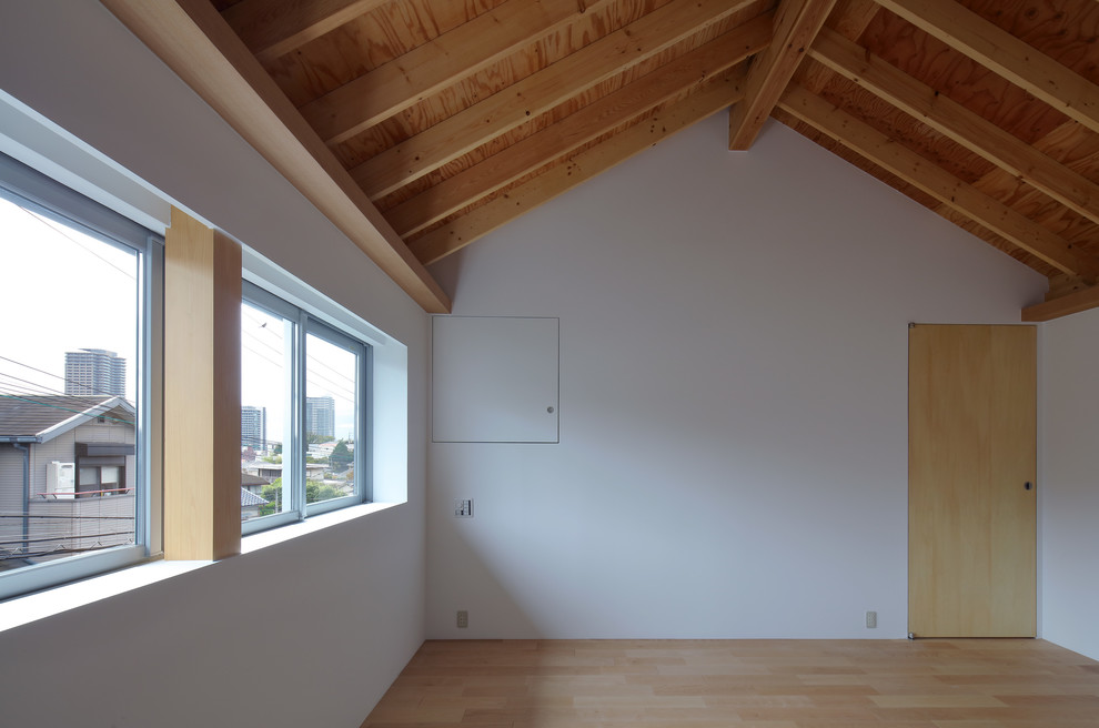 Photo of a mid-sized scandinavian master bedroom in Osaka with white walls, plywood floors, no fireplace and beige floor.