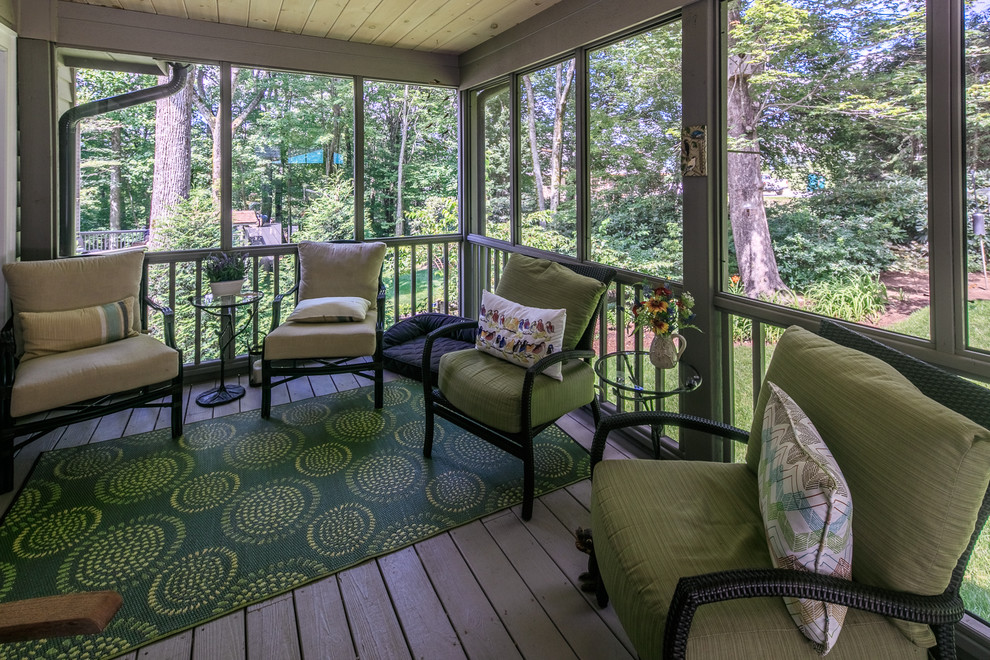 This is an example of a large country backyard screened-in verandah in Charlotte with decking and a roof extension.