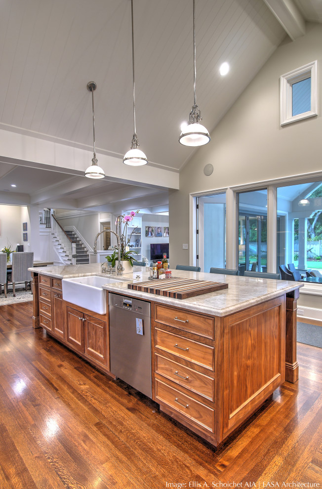 This is an example of an expansive traditional l-shaped eat-in kitchen in San Francisco with a farmhouse sink, recessed-panel cabinets, medium wood cabinets, quartzite benchtops, stainless steel appliances, medium hardwood floors, with island, white benchtop and vaulted.