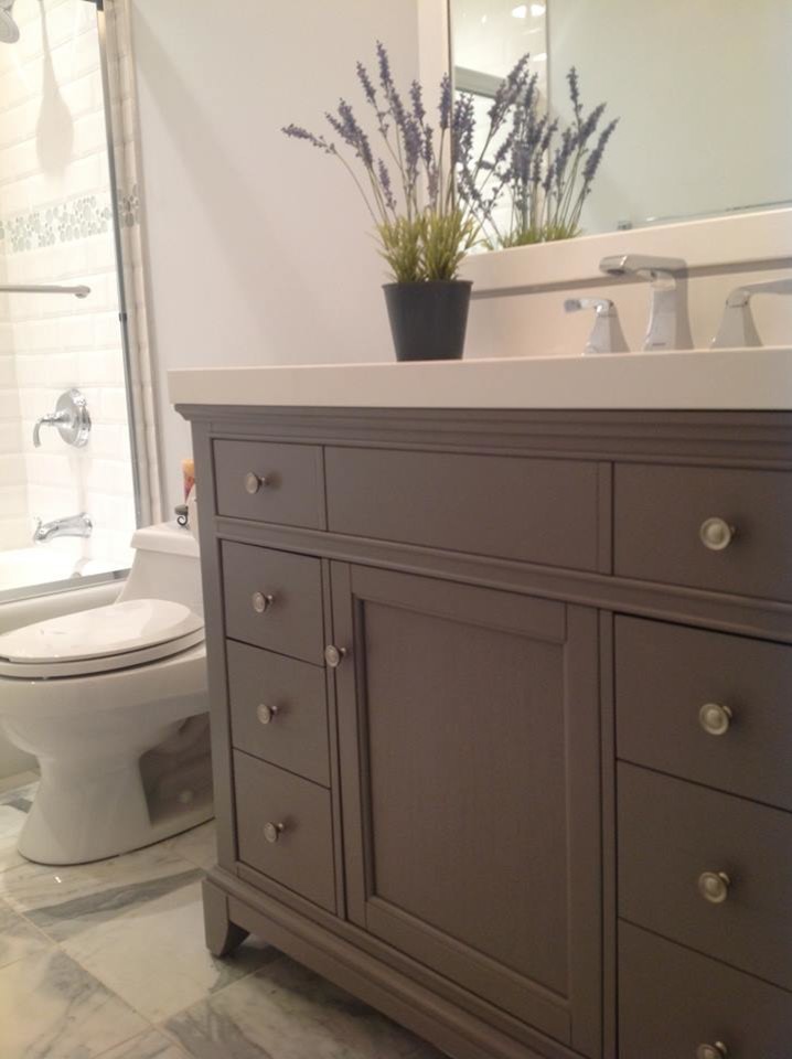Example of a mid-sized transitional multicolored tile and subway tile marble floor alcove bathtub design with an undermount sink, recessed-panel cabinets, gray cabinets, quartz countertops, a one-piece toilet and gray walls