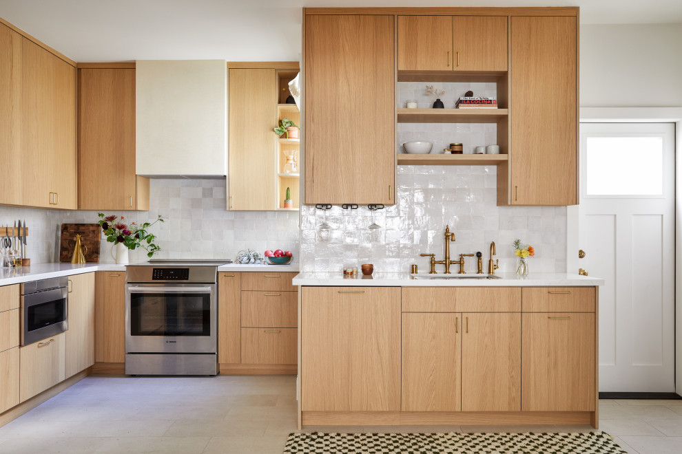 This is an example of a small traditional separate kitchen in San Francisco with an undermount sink, flat-panel cabinets, light wood cabinets, quartz benchtops, white splashback, terra-cotta splashback, stainless steel appliances, porcelain floors, no island, grey floor and white benchtop.