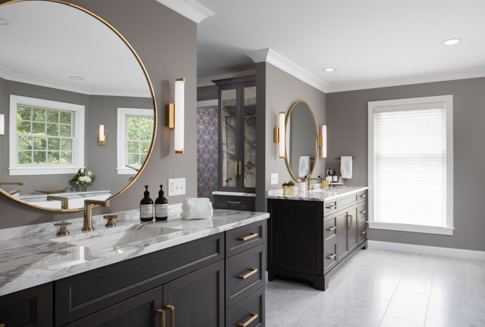 Photo of an expansive transitional master bathroom in Other with recessed-panel cabinets, dark wood cabinets, a freestanding tub, a two-piece toilet, gray tile, marble, grey walls, marble floors, an undermount sink, granite benchtops, grey floor, a sliding shower screen, white benchtops, an enclosed toilet, a double vanity and a freestanding vanity.