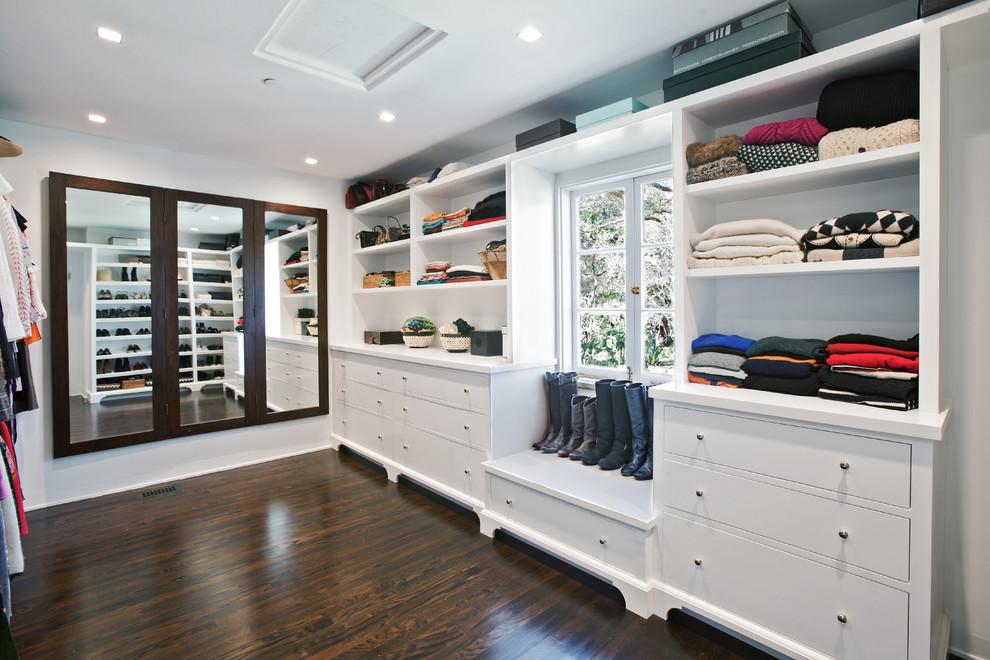 Inspiration for a transitional women's walk-in wardrobe in Santa Barbara with flat-panel cabinets, white cabinets, dark hardwood floors and brown floor.