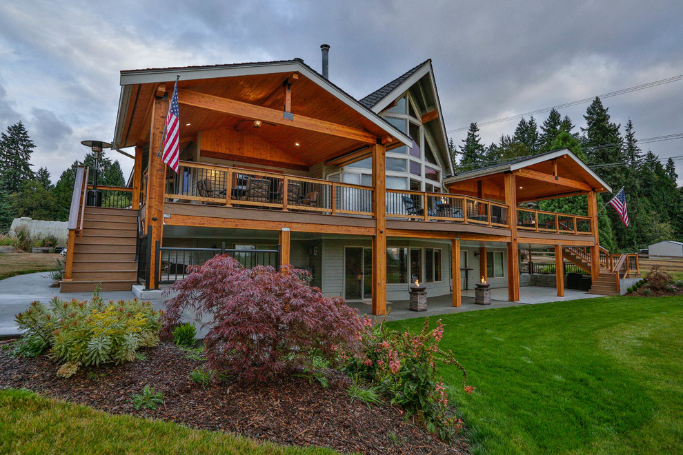 Inspiration for a large rustic backyard outdoor kitchen deck remodel in Seattle with a roof extension