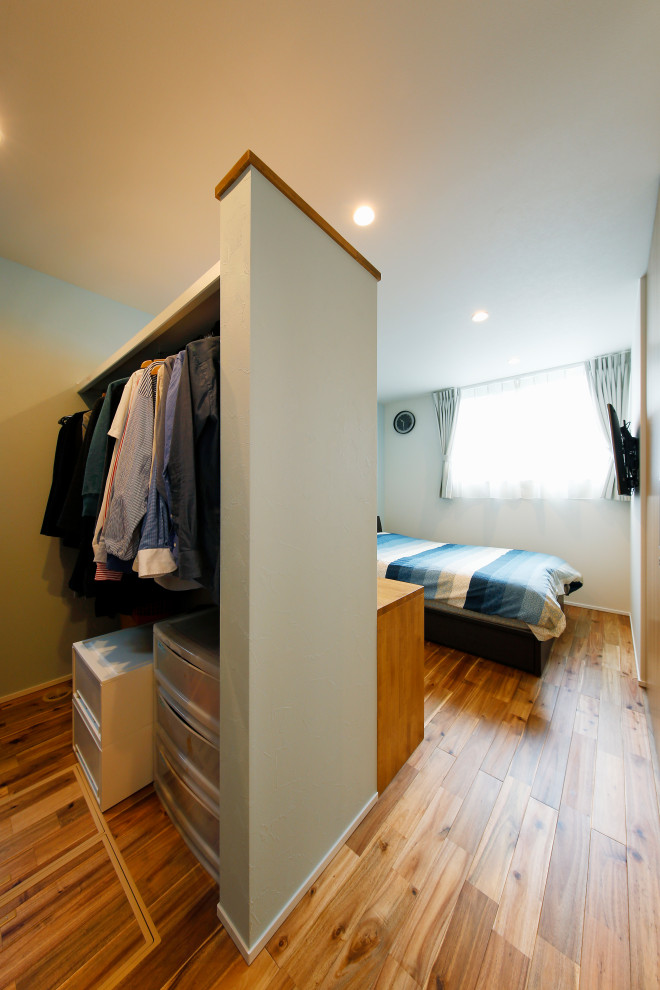 Inspiration for a mid-sized mediterranean women's walk-in wardrobe in Tokyo Suburbs with open cabinets, medium hardwood floors and brown floor.
