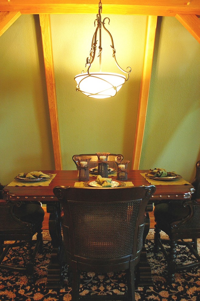This is an example of a small arts and crafts separate dining room in Nashville with green walls and light hardwood floors.