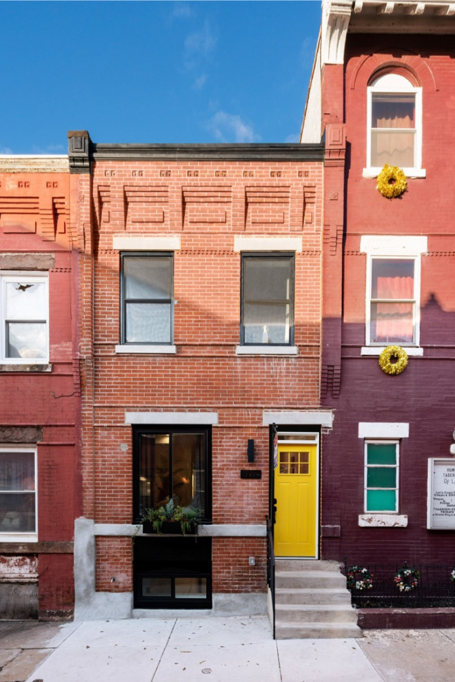 Small contemporary front door in Philadelphia with multi-coloured walls, light hardwood floors, a single front door, a yellow front door and brown floor.