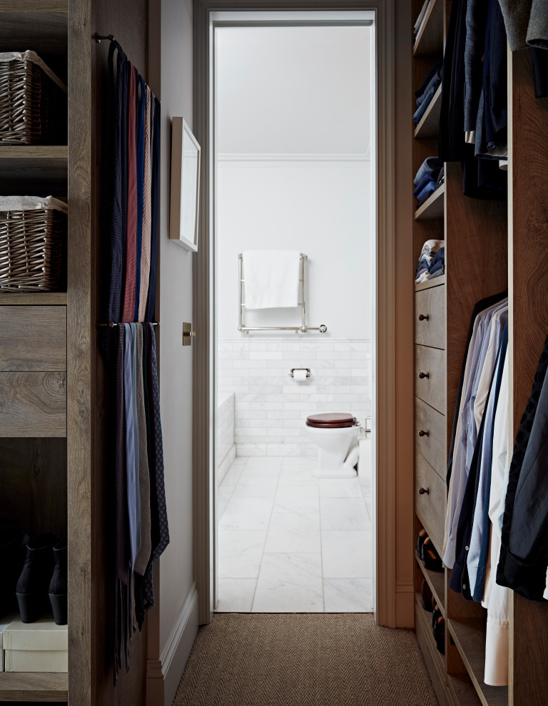 Inspiration for a small classic gender neutral walk-in wardrobe in London with flat-panel cabinets, medium wood cabinets and carpet.