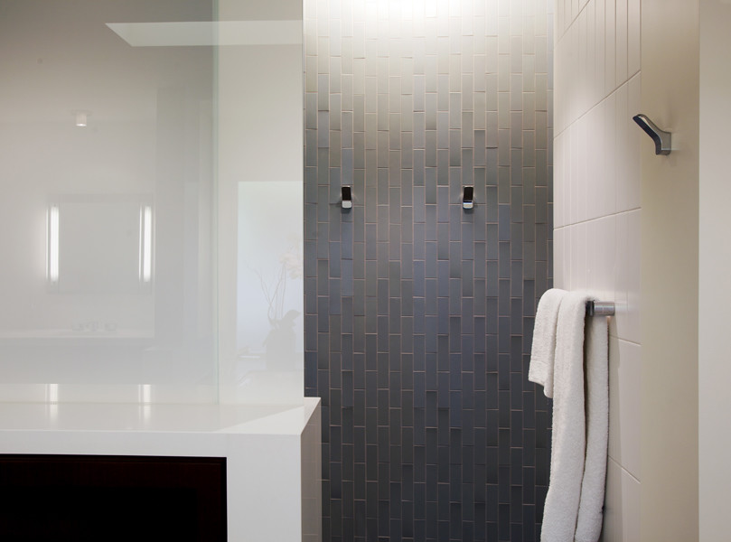 Photo of a large modern master bathroom in Los Angeles with flat-panel cabinets, dark wood cabinets, an undermount tub, an alcove shower, a one-piece toilet, blue tile, ceramic tile, white walls, limestone floors, an undermount sink and engineered quartz benchtops.