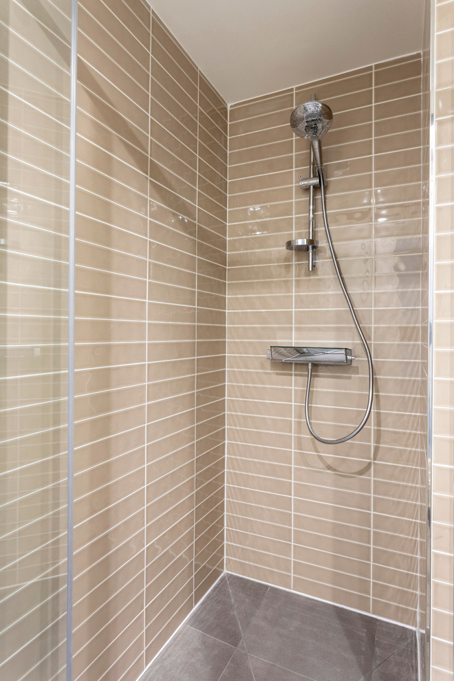 Photo of a small contemporary 3/4 bathroom in Other with glass-front cabinets, an alcove shower, beige tile, ceramic tile, beige walls, ceramic floors, grey floor and a hinged shower door.