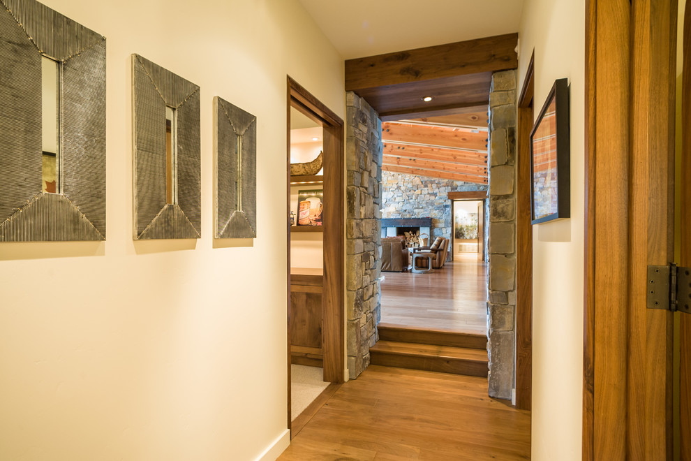 This is an example of a country hallway in Seattle with beige walls, medium hardwood floors and brown floor.