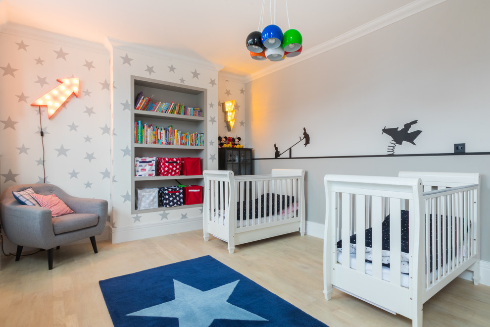 Photo of a transitional gender-neutral nursery in London with grey walls, light hardwood floors and beige floor.