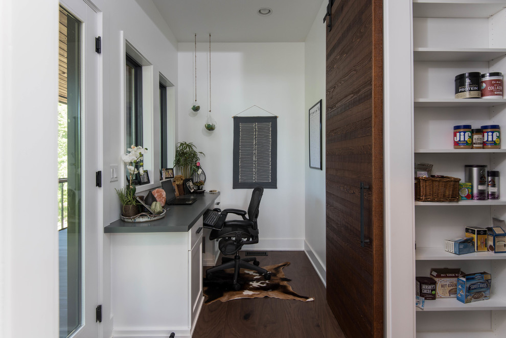 Mid-sized country study room in Other with white walls, dark hardwood floors, a built-in desk and brown floor.