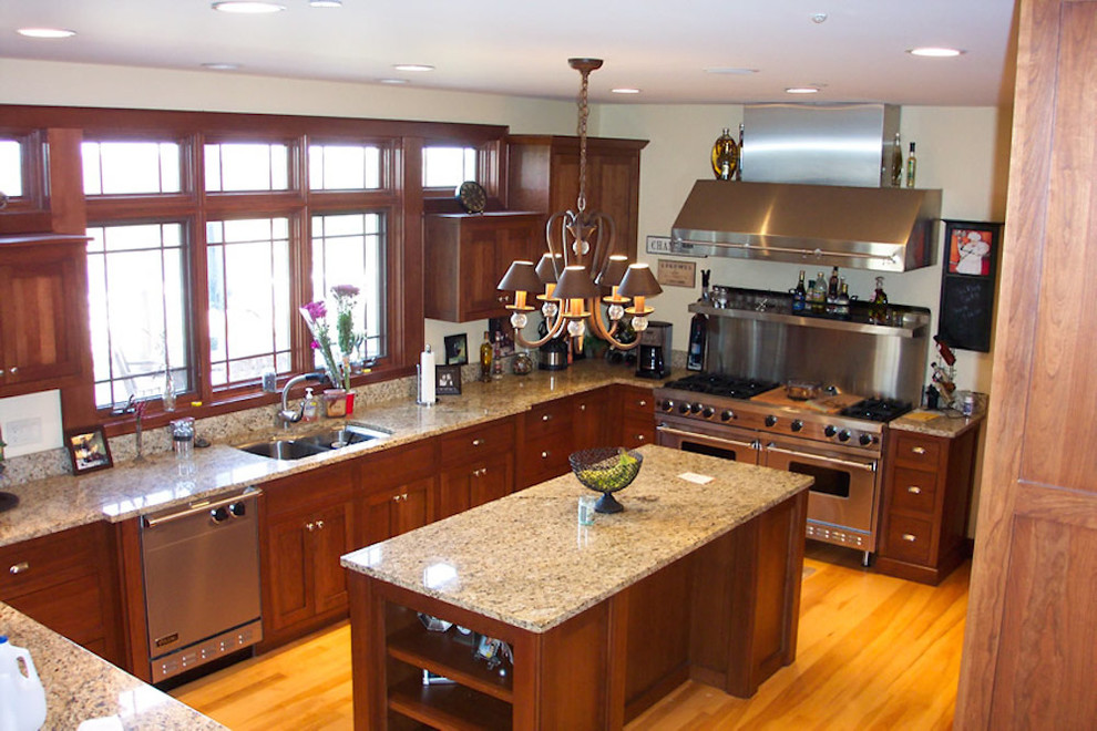 Inspiration for a transitional u-shaped light wood floor kitchen remodel in Milwaukee with a double-bowl sink, recessed-panel cabinets, medium tone wood cabinets, stainless steel appliances and an island