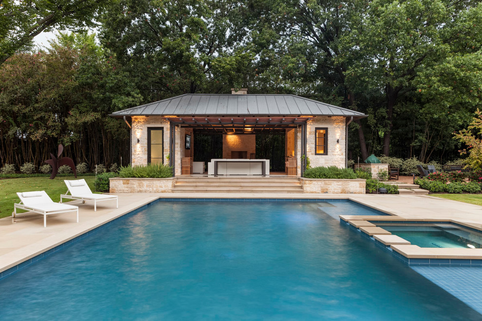Inspiration for a transitional backyard custom-shaped pool in Dallas with a pool house and natural stone pavers.