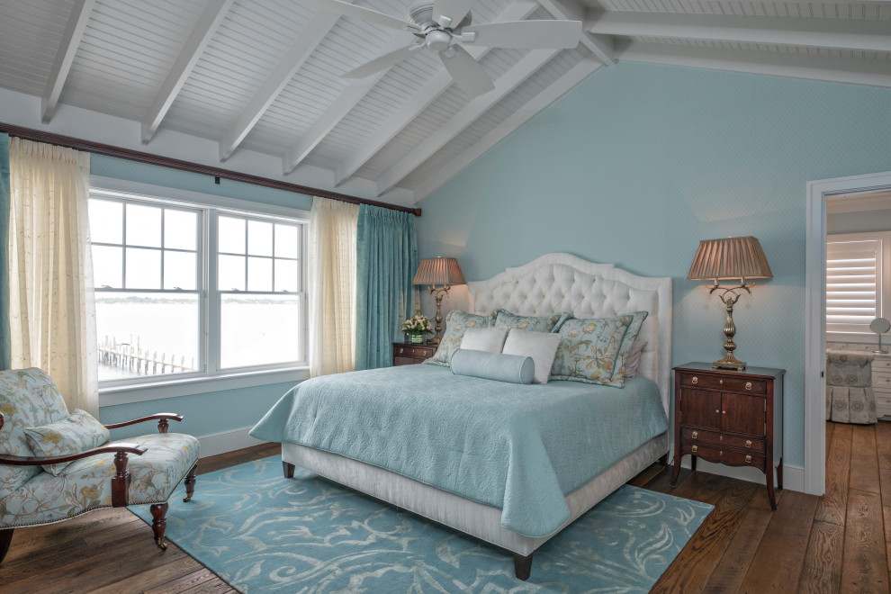 This is an example of a beach style bedroom in Miami with blue walls, dark hardwood floors, brown floor, exposed beam and vaulted.