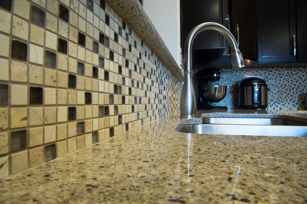 Eat-in kitchen - mid-sized modern u-shaped porcelain tile eat-in kitchen idea in Phoenix with an undermount sink, flat-panel cabinets, dark wood cabinets, quartzite countertops, multicolored backsplash, glass sheet backsplash, stainless steel appliances and no island