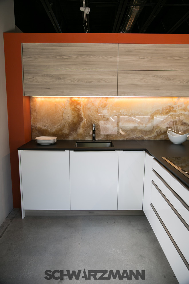 This is an example of a mid-sized modern l-shaped open plan kitchen in Miami with an undermount sink, flat-panel cabinets, yellow cabinets, quartz benchtops, orange splashback, stone slab splashback, stainless steel appliances, concrete floors and a peninsula.