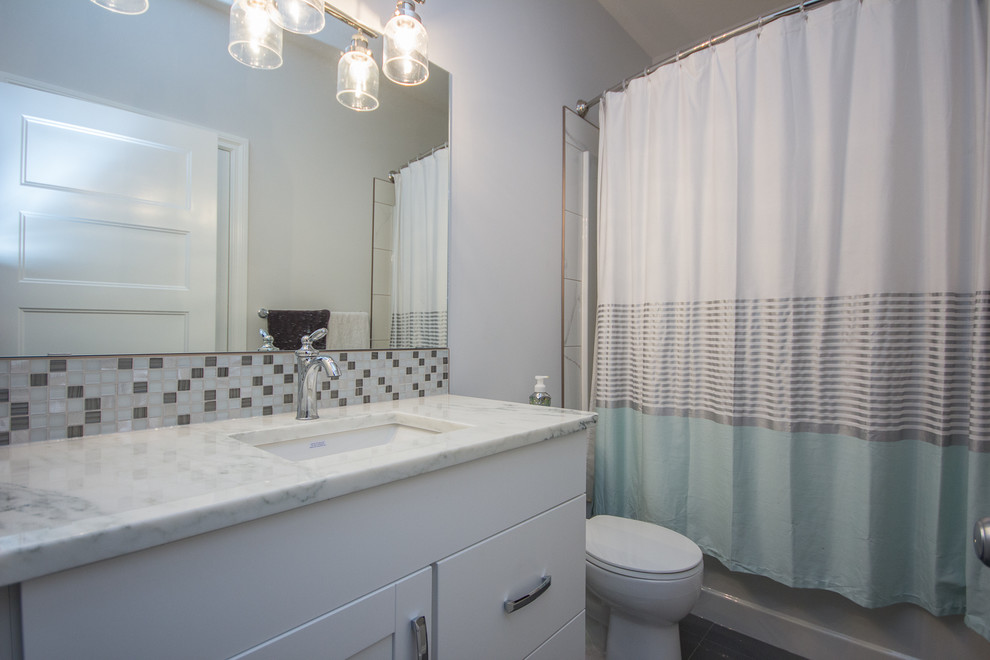 Alcove bathtub - mid-sized transitional 3/4 multicolored tile and mosaic tile porcelain tile alcove bathtub idea in Calgary with shaker cabinets, white cabinets, white walls, an undermount sink and quartzite countertops