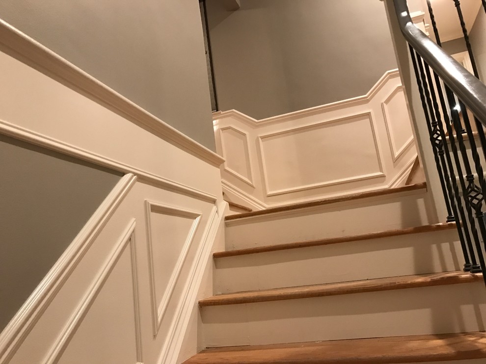 Photo of a mid-sized traditional wood u-shaped staircase in Detroit with wood risers.