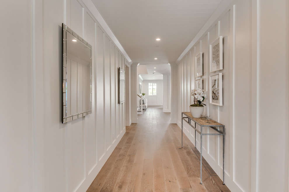 Large contemporary hallway in Los Angeles with white walls, medium hardwood floors and brown floor.