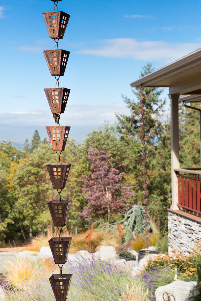 This is an example of a large rustic drought-tolerant and full sun front yard gravel water fountain landscape.