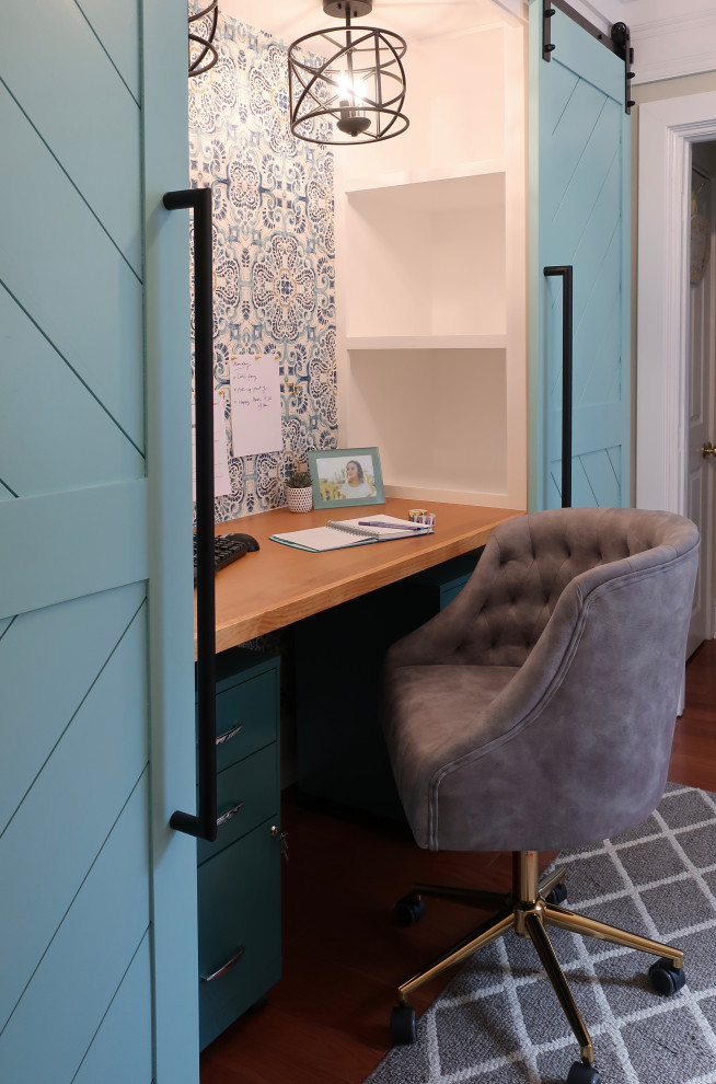 Ejemplo de despacho actual pequeño con paredes azules, escritorio empotrado, papel pintado, suelo de madera en tonos medios y suelo marrón