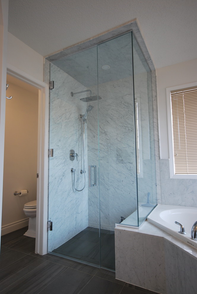Mid-sized traditional master bathroom in Calgary with shaker cabinets, grey cabinets, a corner tub, a corner shower, a two-piece toilet, gray tile, stone slab, grey walls, slate floors, an undermount sink, quartzite benchtops, grey floor and a hinged shower door.