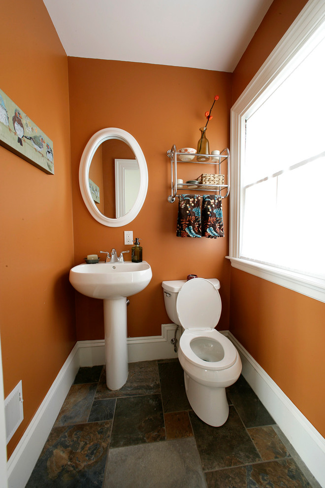 Photo of a mid-sized transitional 3/4 bathroom in Boston with a pedestal sink, a two-piece toilet, multi-coloured tile, porcelain tile, orange walls and porcelain floors.