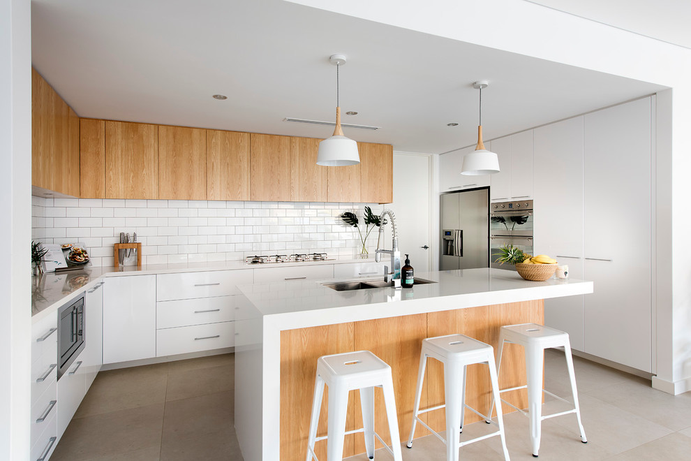 Design ideas for a mid-sized contemporary kitchen in Perth with an undermount sink, quartz benchtops, white splashback, subway tile splashback, stainless steel appliances, porcelain floors and with island.