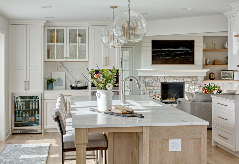 Mid-sized transitional u-shaped medium tone wood floor and brown floor eat-in kitchen photo in Minneapolis with an undermount sink, flat-panel cabinets, white cabinets, quartzite countertops, white backsplash, quartz backsplash, stainless steel appliances, an island and white countertops