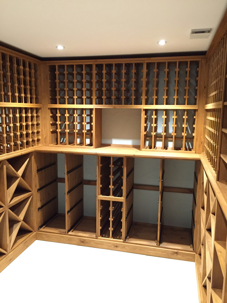 Photo of a large contemporary wine cellar in Sussex with storage racks, concrete floors and grey floor.