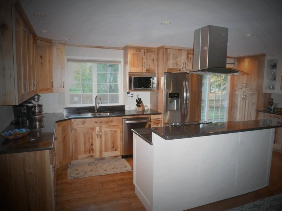 Example of a large mountain style u-shaped medium tone wood floor and brown floor eat-in kitchen design in Seattle with a double-bowl sink, shaker cabinets, light wood cabinets, granite countertops, stainless steel appliances and an island