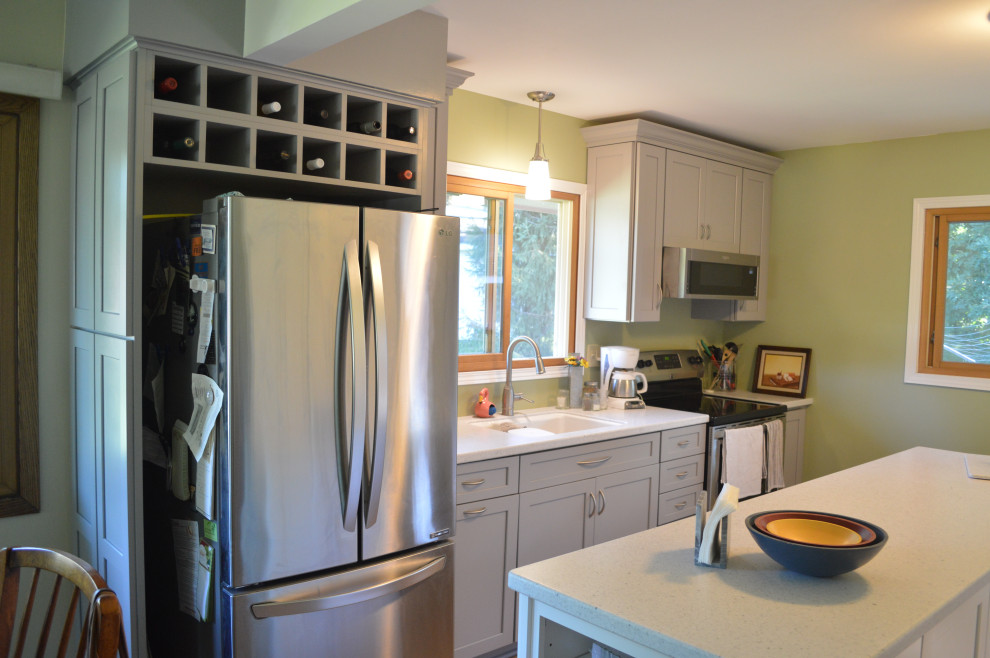 Eat-in kitchen - small transitional single-wall vinyl floor eat-in kitchen idea with an undermount sink, shaker cabinets, gray cabinets, solid surface countertops, stainless steel appliances, an island and white countertops
