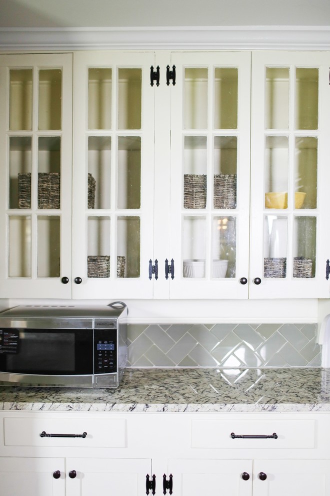 Inspiration for a large transitional dark wood floor eat-in kitchen remodel in Baltimore with an undermount sink, raised-panel cabinets, white cabinets, granite countertops, green backsplash, glass tile backsplash, stainless steel appliances and an island