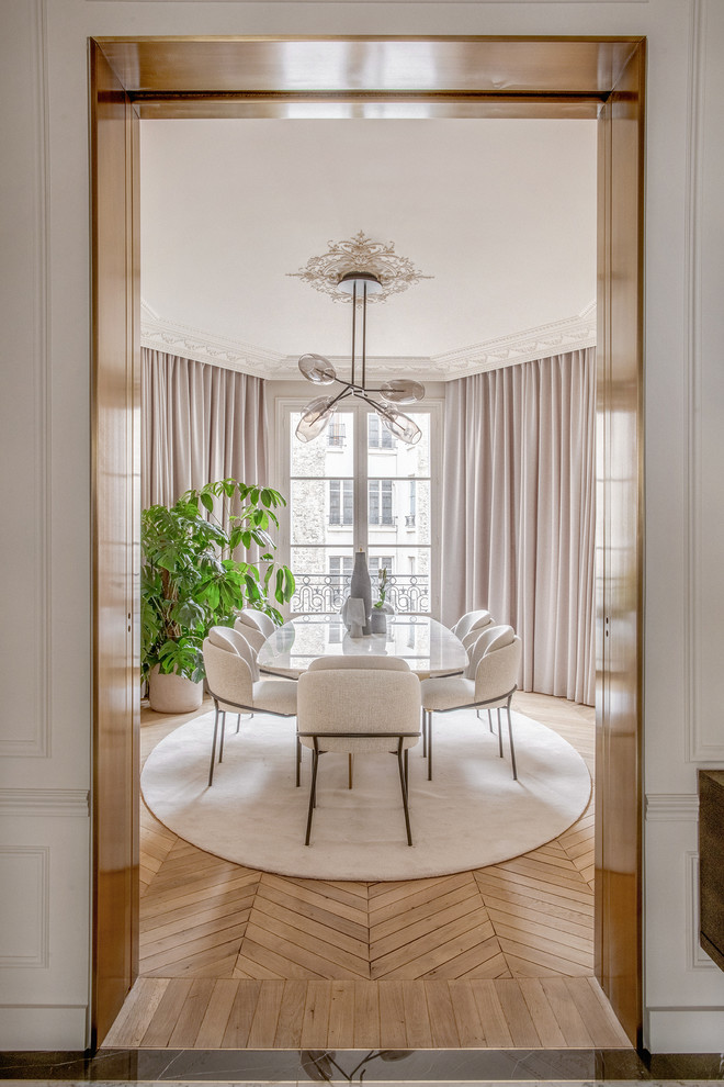 Design ideas for a transitional separate dining room in Paris with white walls, light hardwood floors and brown floor.