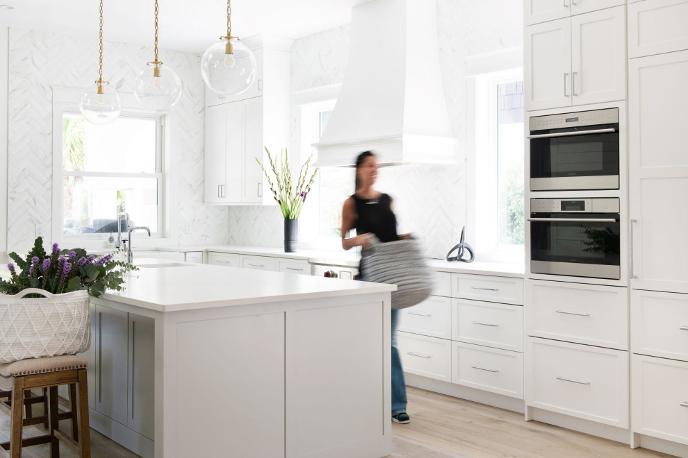 Example of a transitional l-shaped kitchen design in Jacksonville with raised-panel cabinets, white backsplash and marble backsplash