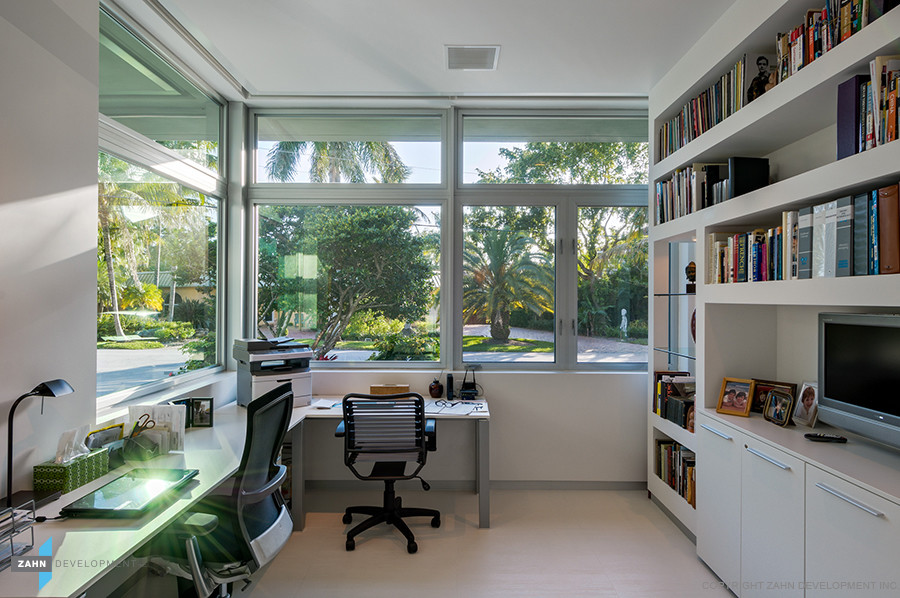 This is an example of a small contemporary home office in Miami with white walls, ceramic floors and a freestanding desk.