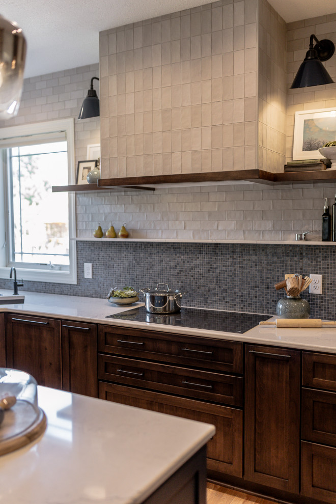 Eat-in kitchen - mid-sized transitional l-shaped medium tone wood floor and brown floor eat-in kitchen idea with an undermount sink, recessed-panel cabinets, dark wood cabinets, quartz countertops, blue backsplash, mosaic tile backsplash, stainless steel appliances, an island and white countertops