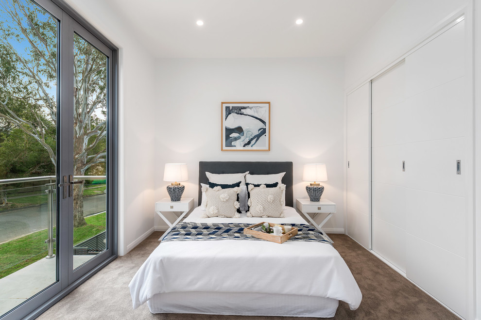 Inspiration for a small contemporary guest bedroom in Sydney with white walls, carpet and brown floor.