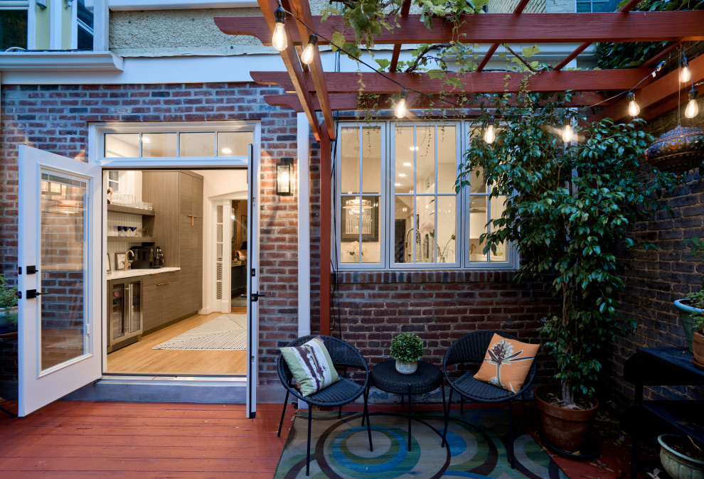 Ejemplo de terraza retro de tamaño medio en patio trasero con privacidad, pérgola y barandilla de madera