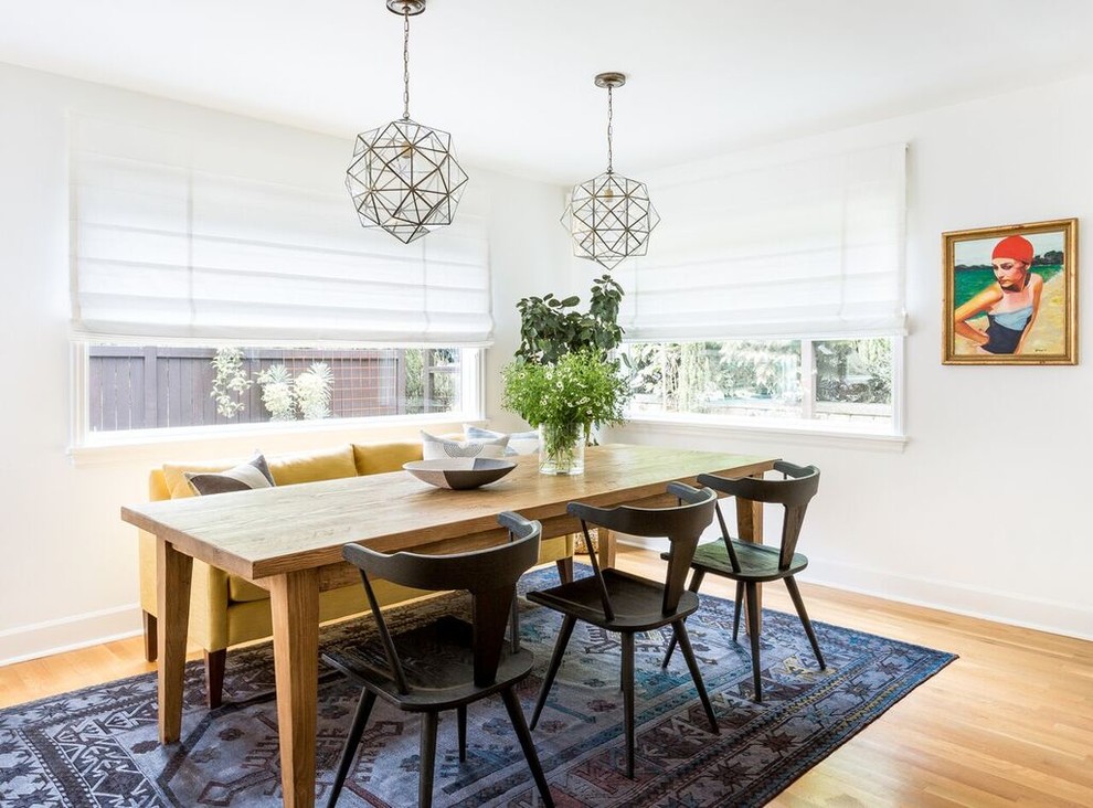 Large scandinavian separate dining room in Seattle with white walls, light hardwood floors, no fireplace and brown floor.