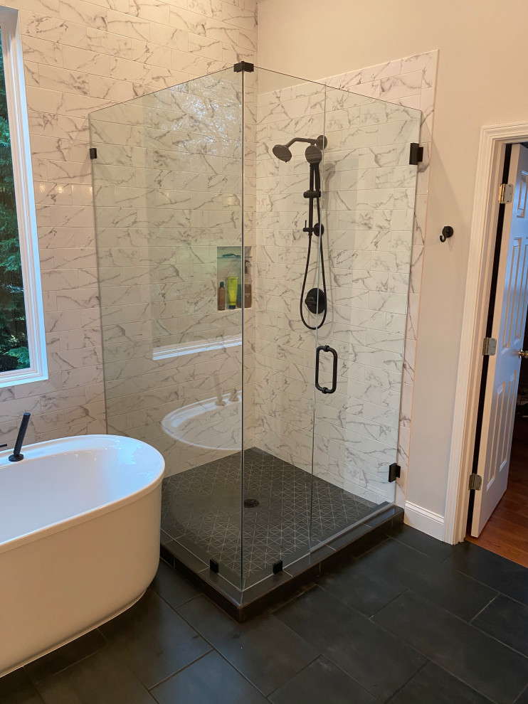 Immagine di una stanza da bagno padronale minimalista di medie dimensioni con ante lisce, ante in legno chiaro, mobile bagno freestanding, vasca freestanding, doccia ad angolo, WC a due pezzi, pistrelle in bianco e nero, piastrelle in gres porcellanato, pareti grigie, pavimento in gres porcellanato, lavabo sottopiano, top in quarzo composito, pavimento nero, porta doccia a battente, top grigio, nicchia, due lavabi e soffitto a volta