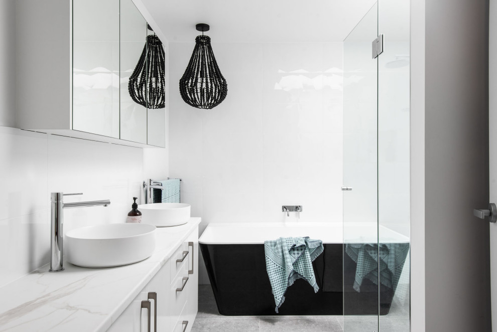 Design ideas for a contemporary bathroom in Hobart with flat-panel cabinets, white cabinets, a freestanding tub, white walls, a vessel sink, grey floor, white benchtops and a double vanity.