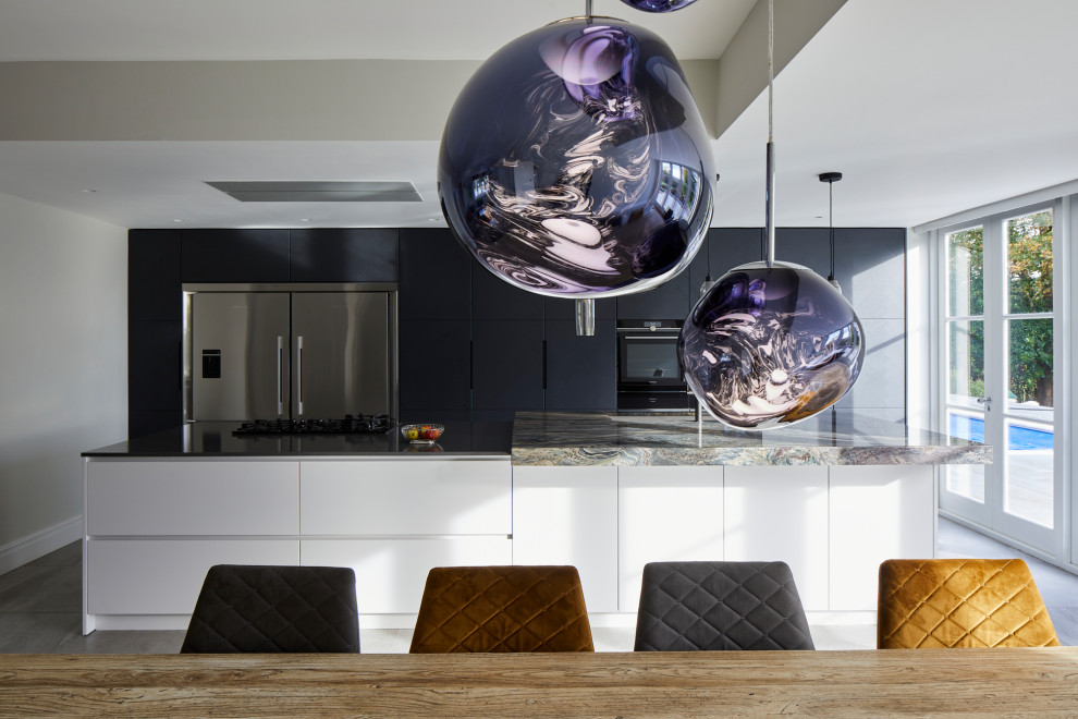 This is an example of an expansive contemporary single-wall kitchen/diner in Kent with flat-panel cabinets, dark wood cabinets, multi-coloured splashback, stone slab splashback, stainless steel appliances, porcelain flooring, an island, grey floors and multicoloured worktops.